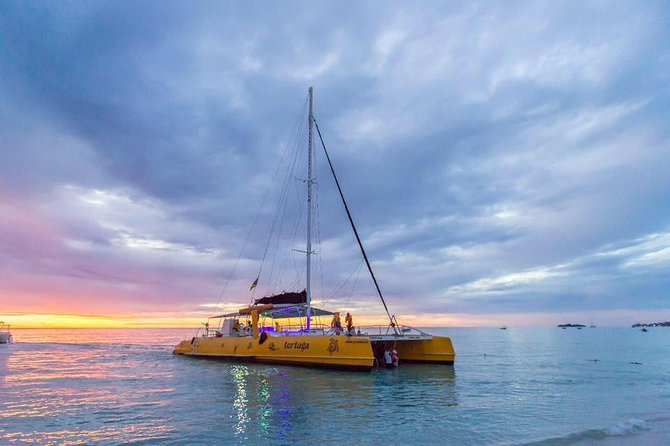 Catamaran Cruise Full Day Tour to Reef, Caves and Negril Beach - Sailing past Rick’s Cafe at sunset